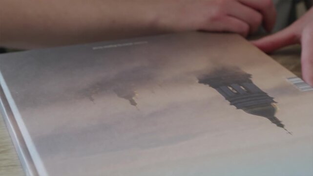 Detailed shot of hands closing a book with a handwritten message inside