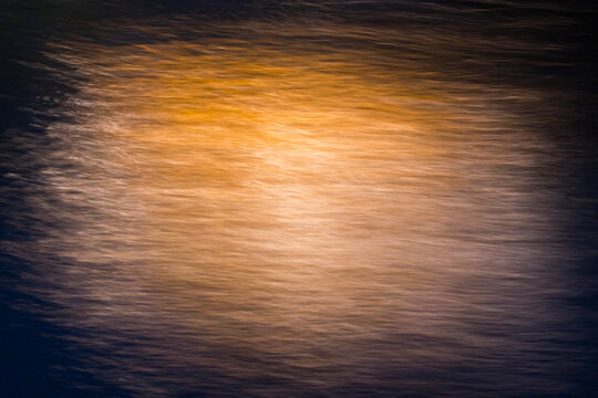 Ethereal golden light streaks on a dark background created with ICM. Abstract motion blur texture conveying energy, innovation, and fluidity. Perfect for sophisticated minimalist designs.