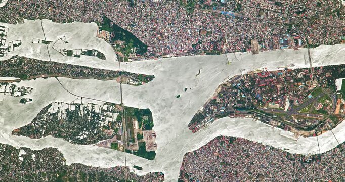 View from above on slums in big city with river. Camera is moving forward and right. Animation based on image by NASA