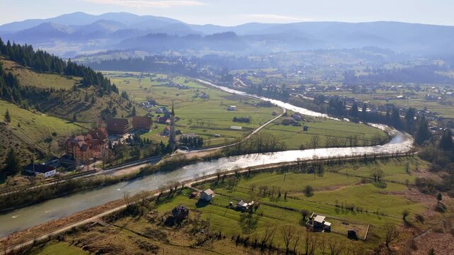 Aerial drone view of a winding river forming a dramatic bend in Dorna Valley near Vatra Dornei, Romania