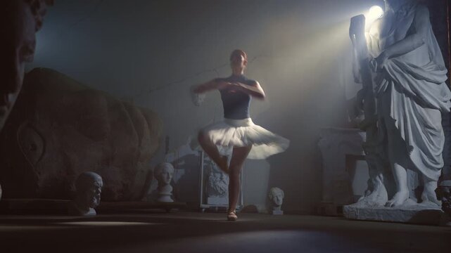 Graceful young ballerina dancing alone in darkness and enjoying classical music. Contemporary dance performance with classic choreography in dark museum, student of school of arts rehearsing in night