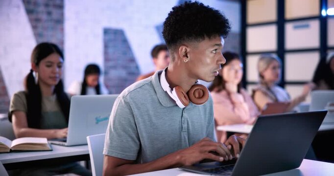 Man, laptop and typing in classroom at college for notes, review and development with education. Person, computer and students with attention for learning, scholarship and assessment at university