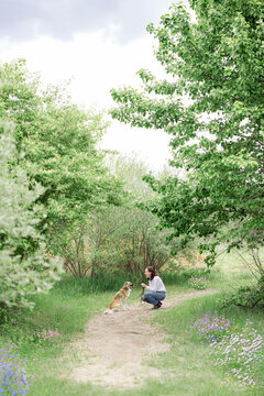 Smiling woman with her dog on a beautiful forest path