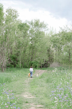 Woman walking her two dogs on a nature trail