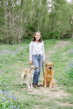 Smiling woman standing with her two dogs outdoors