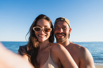 Obraz premium Young couple smiling at camera enjoying summer vacation