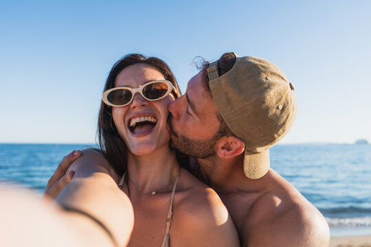 Young couple enjoying romantic kiss on summer beach