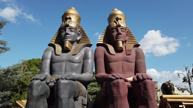 Decorative Egyptian sphinx statues displayed outdoors in Verona city square with historic architecture and blue sky during sunny daytime in Italy.