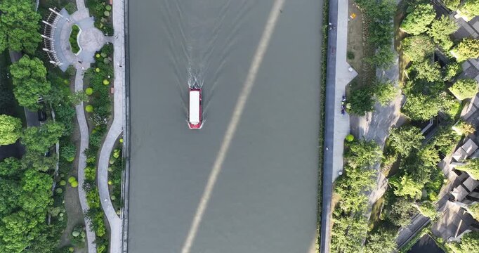 Aerial Top View of Boat on Urban River Between Tree Lined Promenades