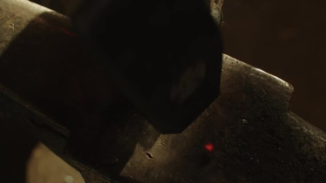 Close-up of a red-hot metal tip being hammered on an anvil, gradually reshaping it, showcasing blacksmithing, craftsmanship, and dramatic forge action.