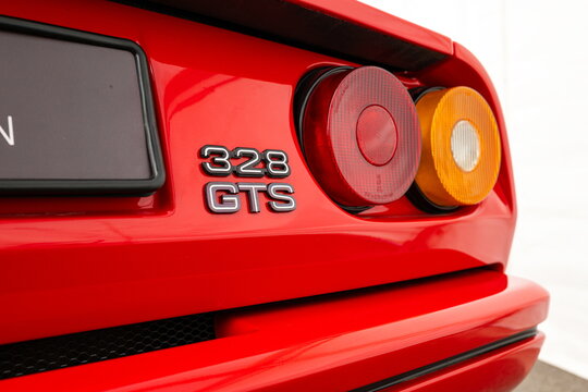 Lucerne, Switzerland, May 30, 2026. Red Ferrari 328 GTS rear tail light panel showing the classic model emblem script badge.