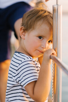 Cute Young Boy By The Lake At Sunset