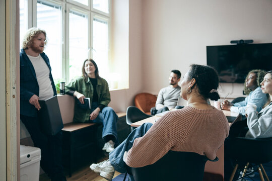 Female business expert sitting in meeting with colleagues at startup office