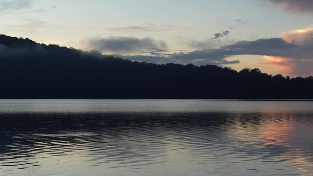 Serene morning view of Lake Beratan in Bali with gentle water ripples at twilight.