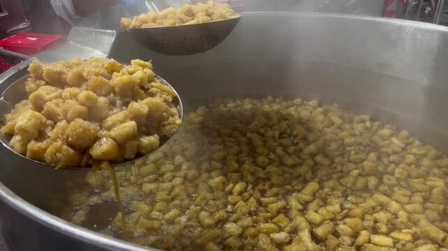 Fish maw being cooked in a steam-heated industrial kettle during food manufacturing operations. Large-scale food processing procedure supporting ingredient preparation, product consistency, and commer