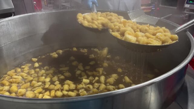 Fish maw being cooked in a steam-heated industrial kettle during food manufacturing operations. Large-scale food processing procedure supporting ingredient preparation, product consistency, and commer