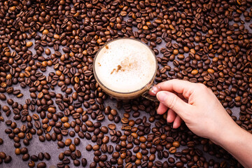 Naklejka premium Hand holding a round soap bar above coffee beans
