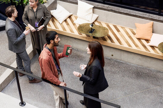 High angle view of male entrepreneur talking with female associate at meet and greet event in convention center