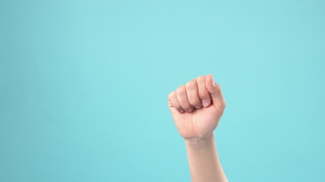 Female hand showing clenched fist sign isolated on blue background