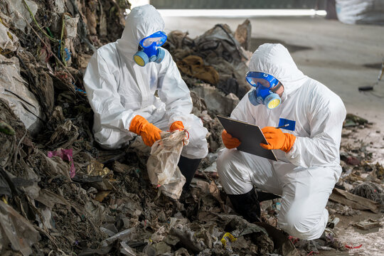 Waste inspecting process at recycling plant:Two experts inspecting waste  meticulously documenting observations.This image highlights environmental monitoring and crucial waste management efforts.