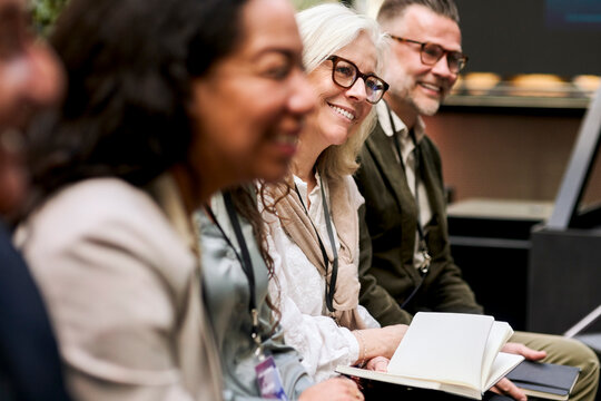 Smiling senior female business entrepreneur attending conference summit in convention center