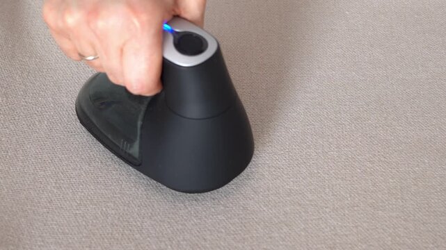Top view hand removes pills from knitted clothing using fabric shaver. Textile pilling. Linting. Fabric lint, pilly, pellet, fluff