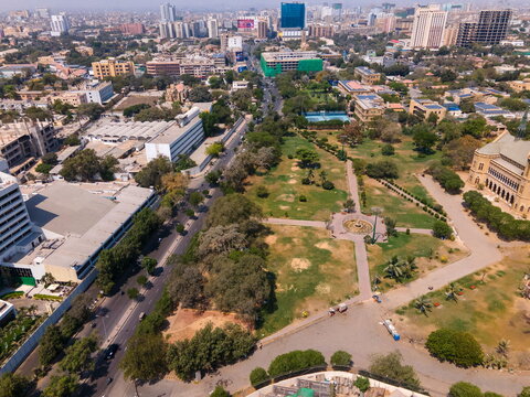 Aerial view of the historic Frere Hall building and its lush green park grounds surrounded by the urban skyline and city streets in Karachi, Sindh, Pakistan.