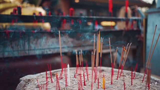 Burning incense sticks with smoke at Buddhist temple ritual in Thailand, Incense smoke during spiritual worship and offering at temple altar 4k