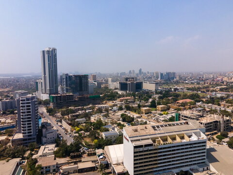 Aerial view of the urban skyline featuring the Marriott Hotel, Bahria Icon Tower, and residential buildings under a clear sky in Karachi, Sindh, Pakistan.