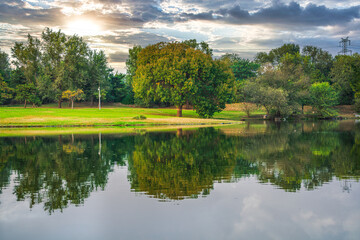 Obraz premium The natural scenery of large trees reflected in the lake in Beijing Olympic Forest Park