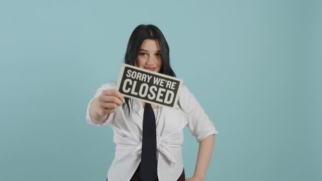Young woman holding a sorry we are closed sign