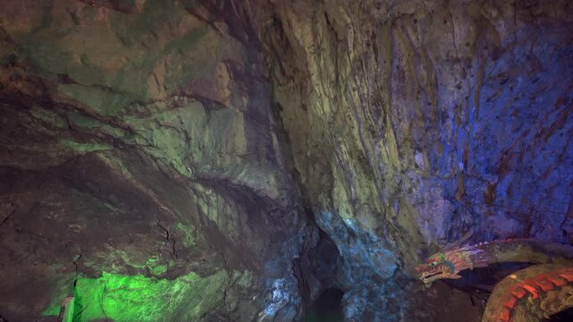 Colorful Illuminated Cave Interior with Rocky Walls and Dragon Sculpture