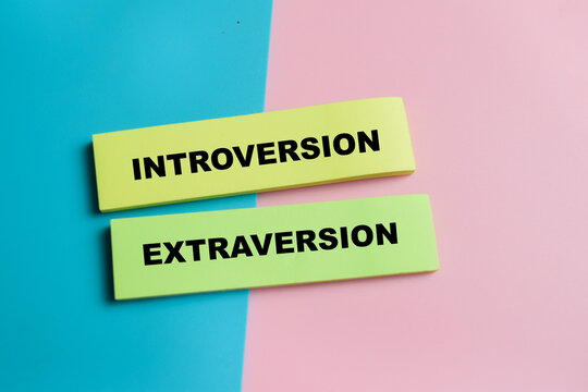Concept of introversion and extraversion write on sticky notes isolated on Wooden Table. For balance of personality traits and human behavior