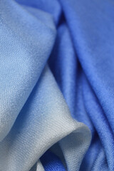 Fototapeta premium A vibrant close-up of flowing blue fabric with an elegant ombre gradient, showcasing fluid, soft folds and a smooth texture perfect for high-end fashion, textile backgrounds, and creative design proje