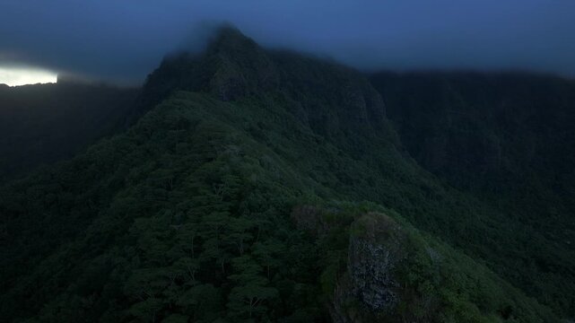Moorea Tahiti island French Polynesia Belvedere Lookout Mount Toheia Mt Rotui aerial drone sunset low dark cloud layer lush green jungle forest volcanic jagged rugged mountain peaks circle right