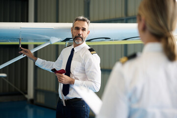 Flight instructor explaining plane pre flight inspection to student pilot © alvaro