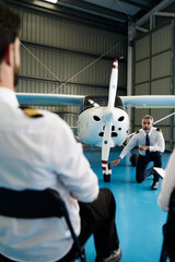 Pilot instructor teaching aviation students about propeller plane © alvaro