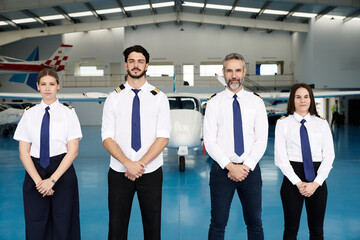 Pilots group standing in hangar with aircraft © alvaro