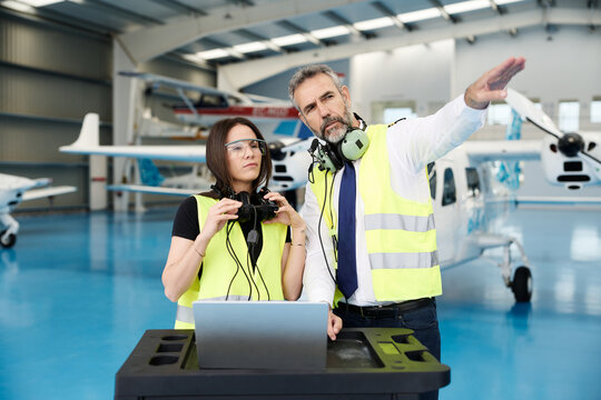 Aviation professionals discussing aircraft maintenance in hangar