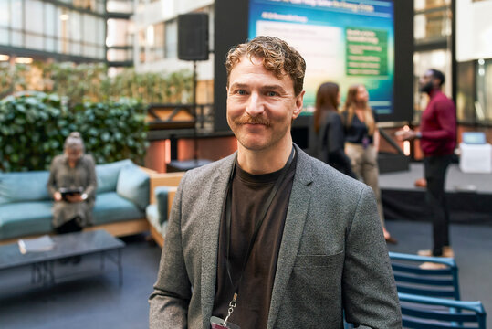 Portrait of smiling mature male business entrepreneur at summit in convention center