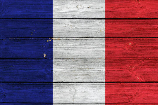 Flag of France on an old wooden surface with cracked paint.