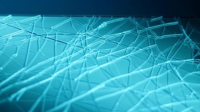 Time lapse slow motion view of cracked glass surface shifting colors and light across studio macro background close up of shattered pane texture and fracture pattern