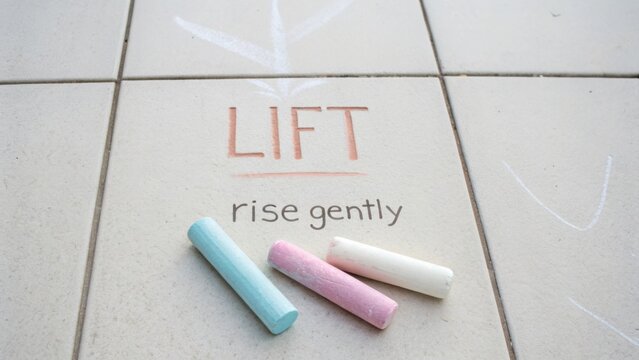 Colorful chalk and uplifting message on pavement urging to lift and rise gently for a positive mindset and inspiring environment