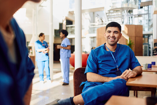 Smiling young male medical nurse sitting at hospital cafeteria