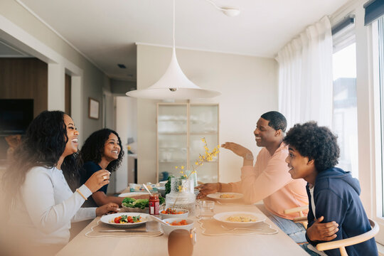 Happy family talking and enjoying during lunch time at home