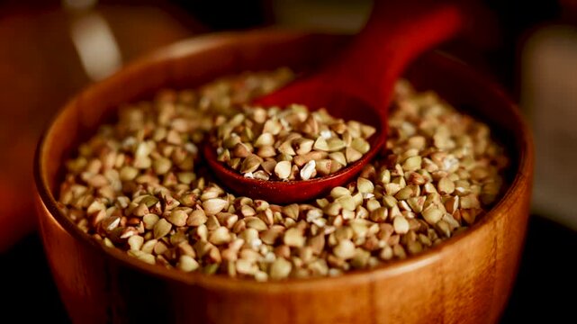 Organic green buckwheat groats in wooden bowl with red spoon ready for healthy meal