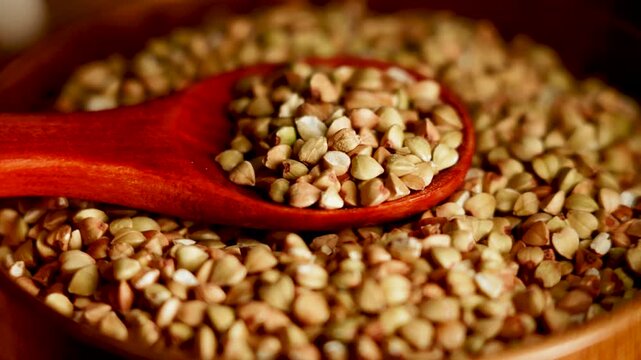Healthy organic green buckwheat groats scooped on wooden spoon