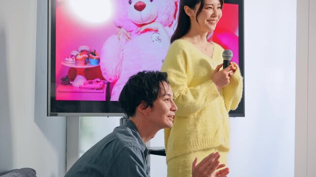 カラオケボックスで歌う男女カップル
