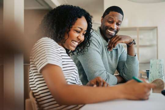 Happy man sitting next to daughter during home study session