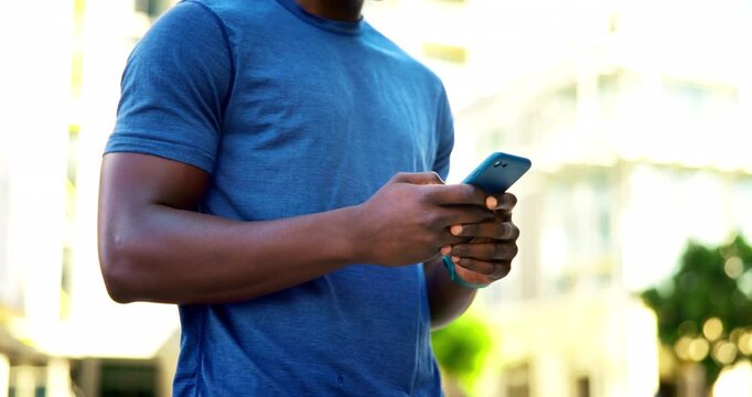 Phone, fitness and hands of man in city with typing for texting, social media or chatting. Athlete, technology and male person scrolling on app for workout program on cellphone in urban town.